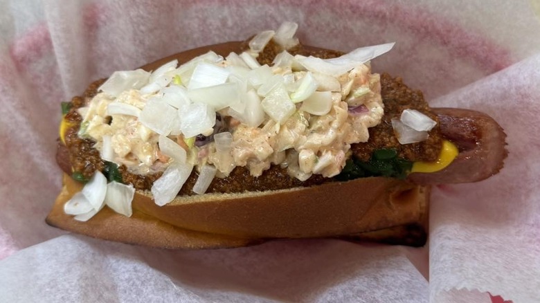 A hot dog with slaw, onions, and other toppings