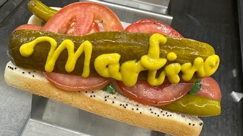 A hot dog with the word "Martino's" written in mustard
