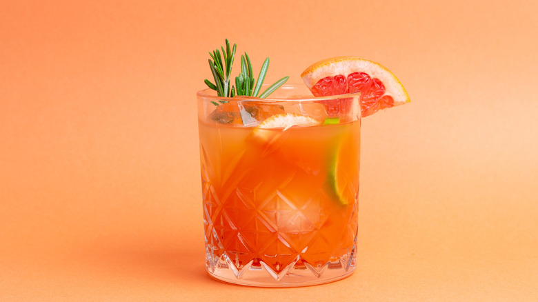 Paloma cocktail with rosemary, grapefruit, and lime granishes