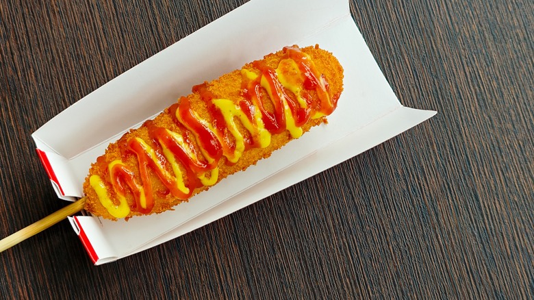Korean corn dog topped with ketchup and mustard