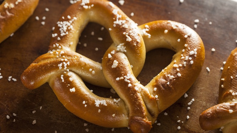 soft pretzels on a wooden cutting board sprinkled with salt