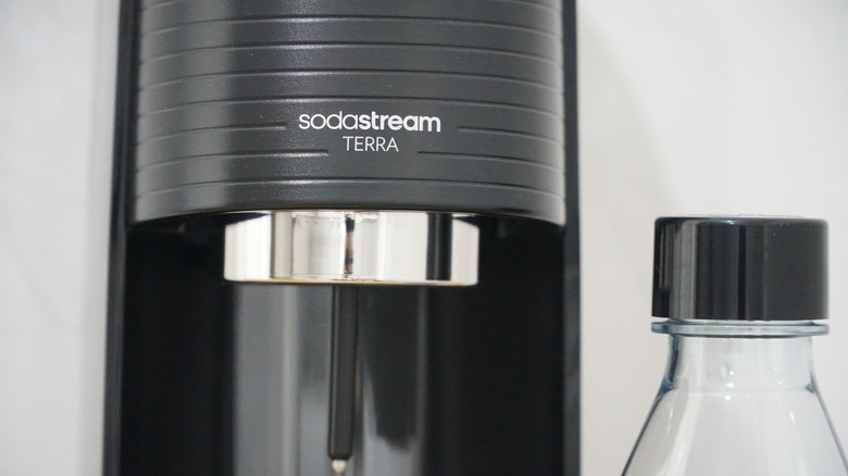 black Sodastream machine and bottle in the kitchen. Terra model. sodastream logo.