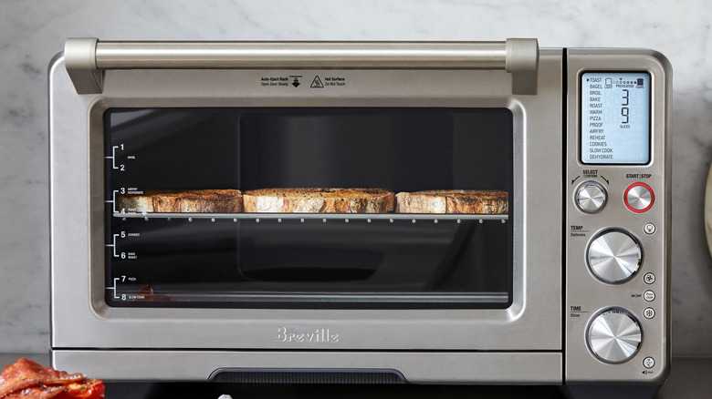 A Breville Smart Toaster Oven sitting on a kitchen counter with toast on the rack