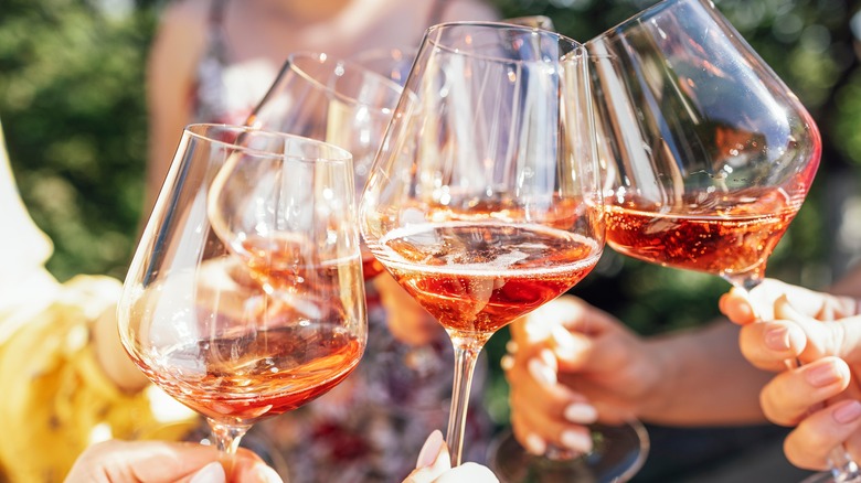 clinking glasses of rosé wine