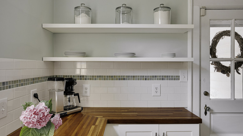 Open shelves in a mostly white kitchen are nice, but plain, before they are properly styled.