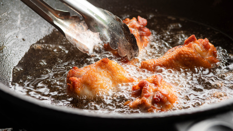 Chicken drumsticks fried in boiling oil.