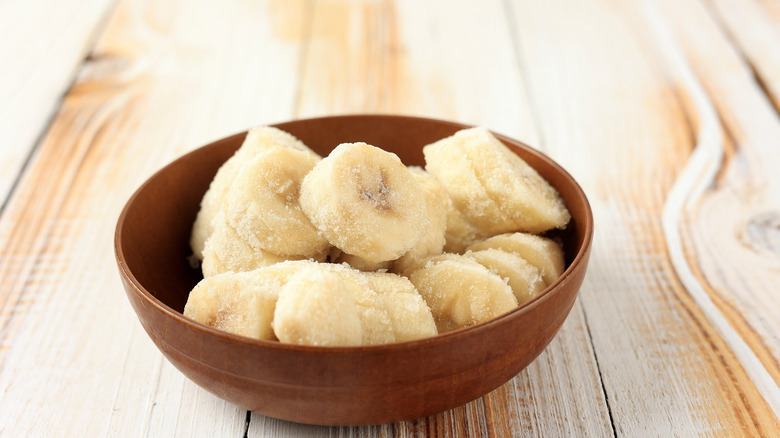Frozen sliced bananas in wooden bowl