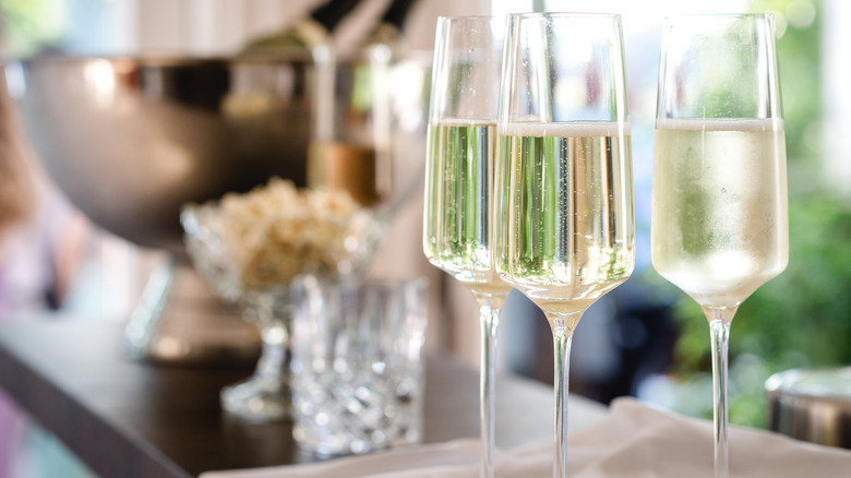 Three champagne glasses filled with champagne on a table