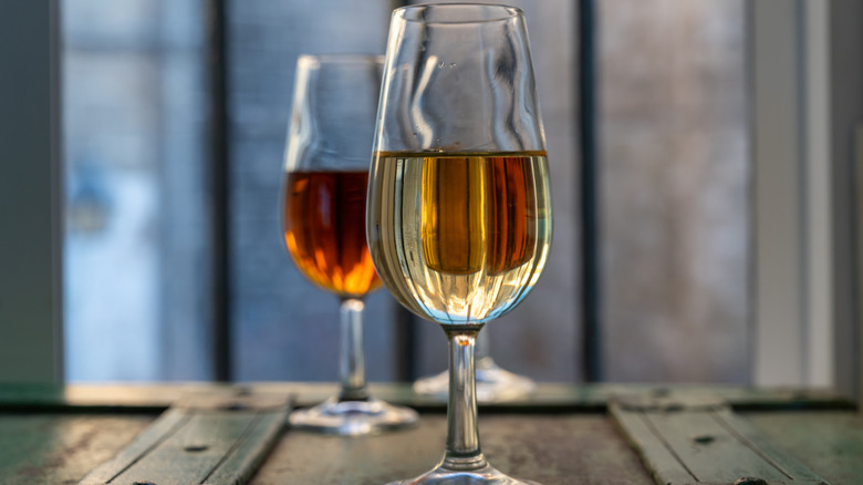 An illustrative image showing two glasses of Sherry on a wooden surface.