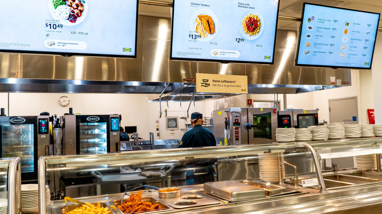 Ikea cafeteria with hot meal options and menu screens.