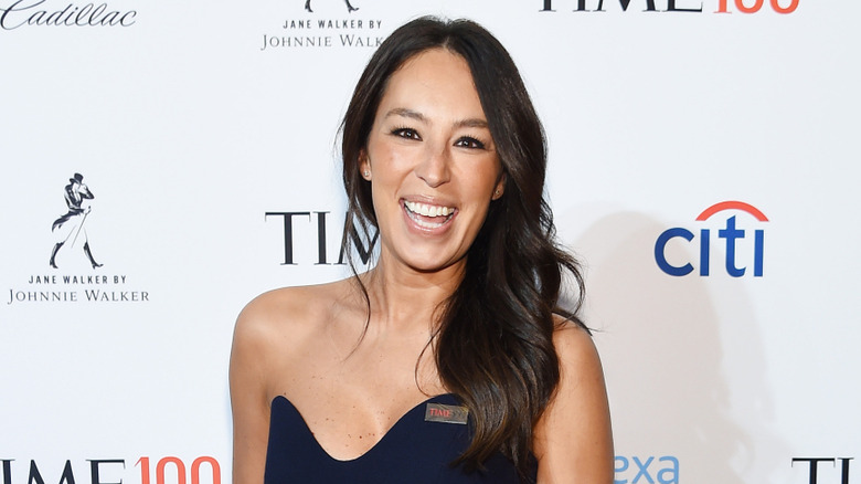 Joanna Gaines smiling and wearing a strapless dress at an event