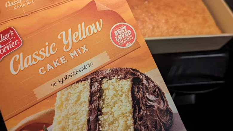 Box of Baker's Corner Classic Yellow Cake Mix with baked cake in background.