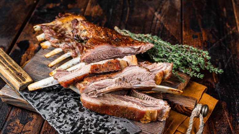 Lamb ribs on a board with knife and fresh thyme