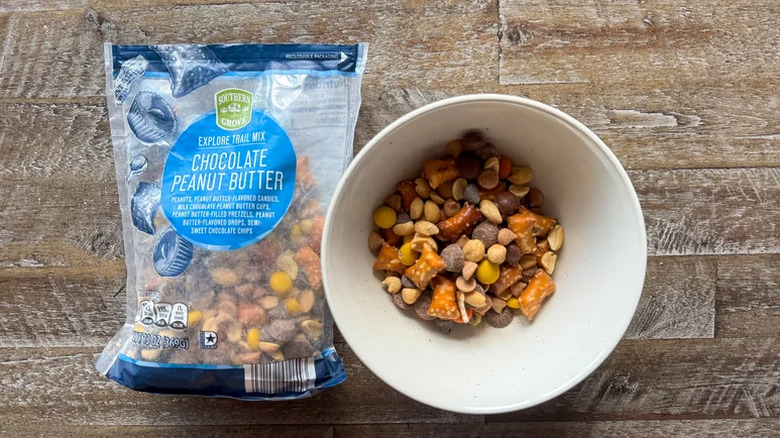 Aldi chocolate peanut butter trail mix in a bowl next to an open bag of it.