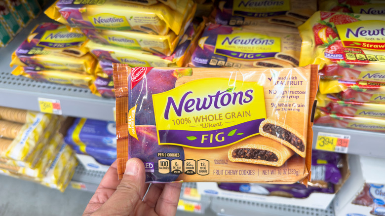 A hand holding a package of Fig Newtons at a store