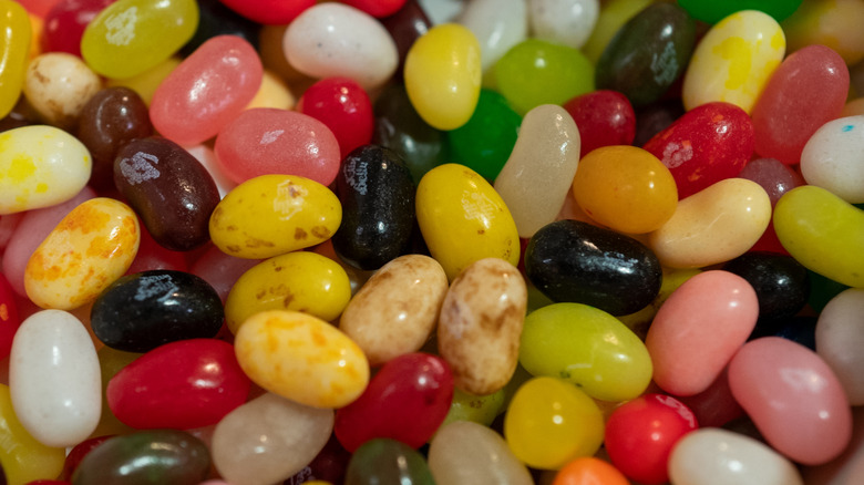 A pile of Jelly Belly jelly beans, with some showing the white Jelly Belly logo