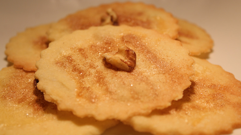 Sand tart cookies dusted with cinnamon sugar and a walnut piece