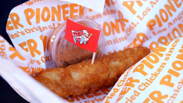 fried chicken piece with Pioneer Chicken branded paper and flag