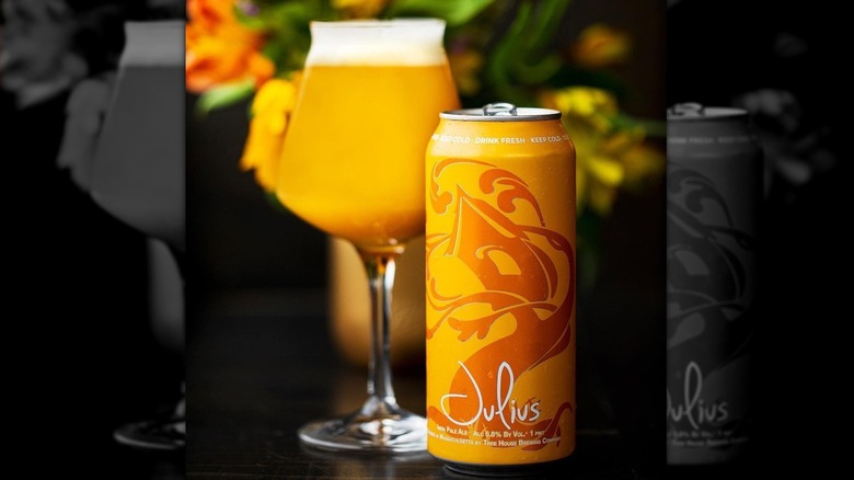 Glass of Tree House Julius with a can of the beer beside it