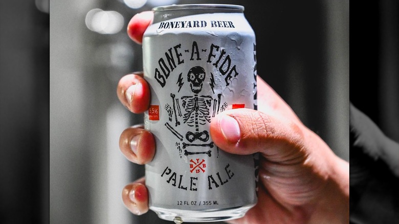Person holding can of Bone-A-Fide Pale Ale