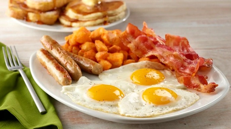 Perkins breakfast plate, including sausage, crispy potatoes, bacon, eggs, pancakes, and French toast