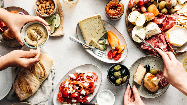 Hands over an appetizer spread