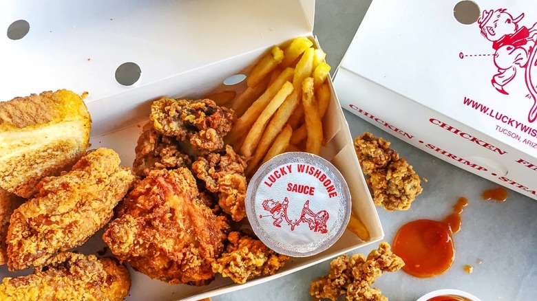 open box from Lucky Wishbone with spilled sauces next to it