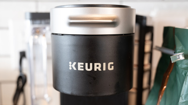 A close-up of a black Keurig coffee maker, with slight signs of use