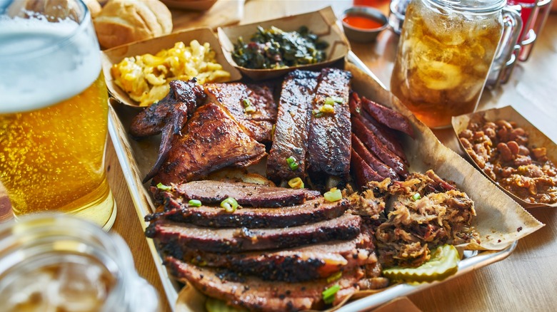 Barbecued meat with sides on a metal tray.