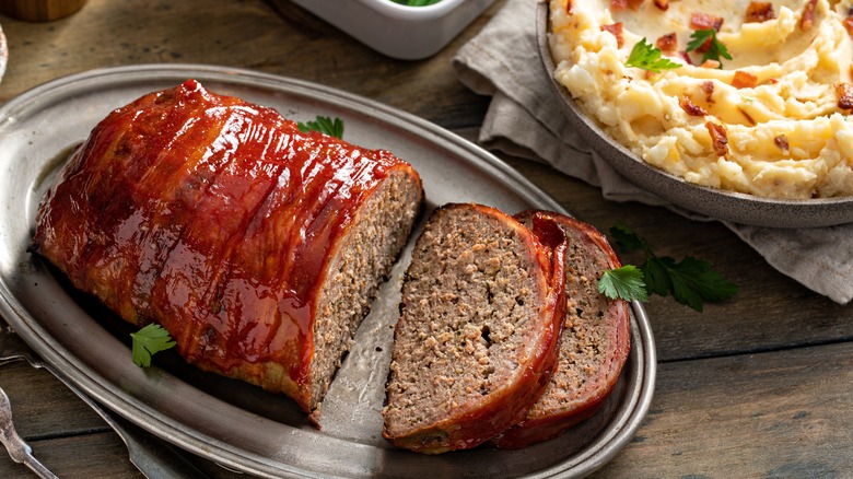A bacon-wrapped meatloaf on a platter