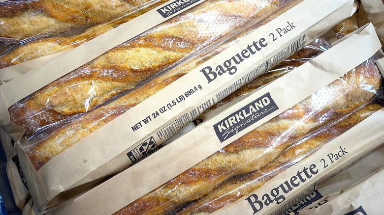 Costco's Kirkland Signature baguettes in plastic and brown paper sheaths