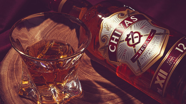 Chivas 12 Year bottle next to a rocks glass with whisky