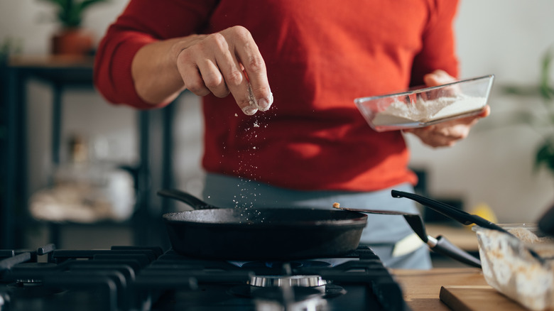 Man adds salt to recipe