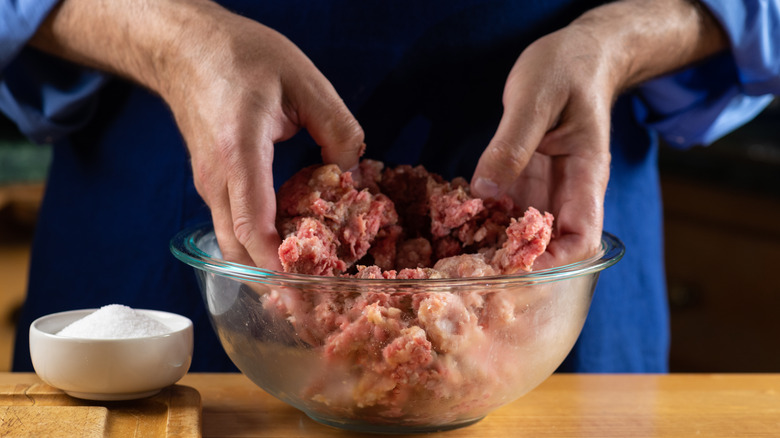 Hands mixing ground beef