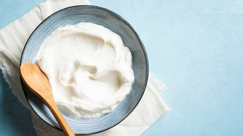Bowl of sour cream with wooden spoon