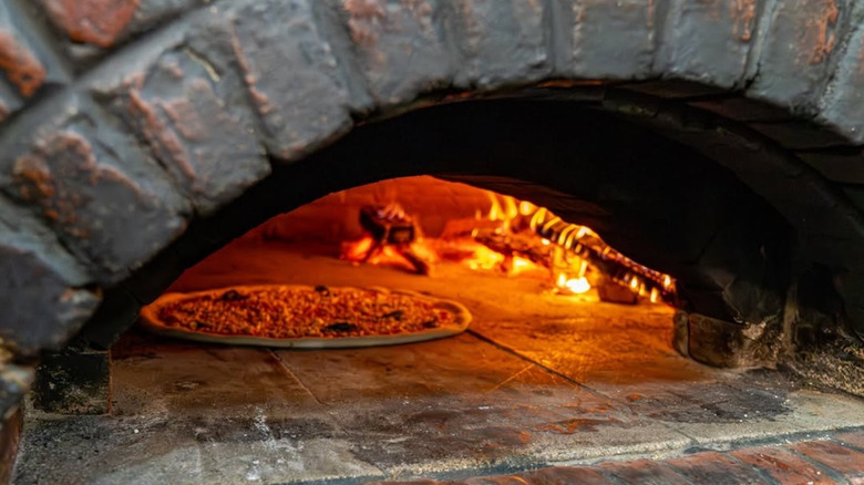 A whole pizza in the wood-fired oven at Best Pizza.