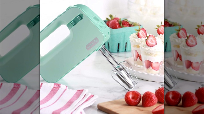 Aqua Dash Smartstore Hand Mixer resting on counter next to strawberries and strawberry parfaits