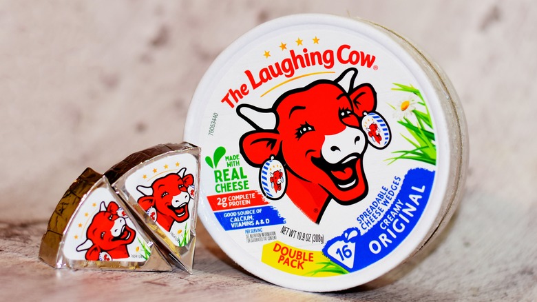 The Laughing Cow spreadable cheese wedges next to a circular package of Laughing Cow cheese
