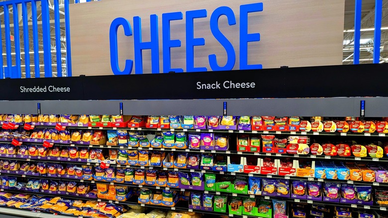 The cheese section of a supermarket with a blue sign