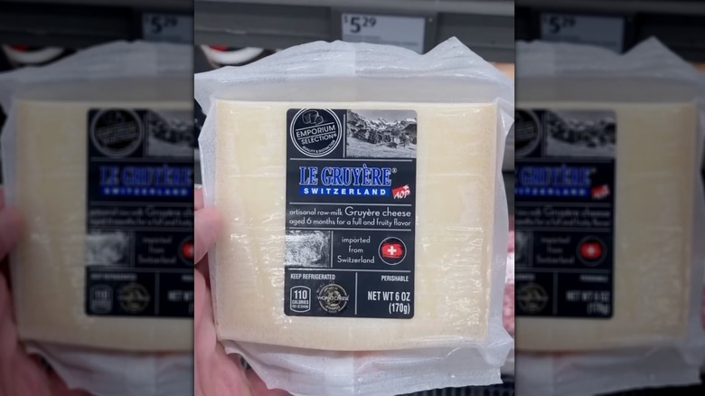 A man holding a package of Le Gruyère cheese