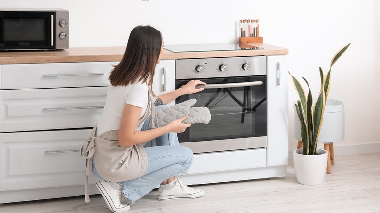 woman opening oven