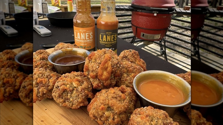 Fried food with bowls of Lane's BBQ sauce on an outdoor table
