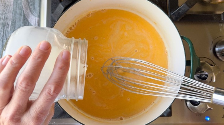 whisking milk into beer cheese dip in pot