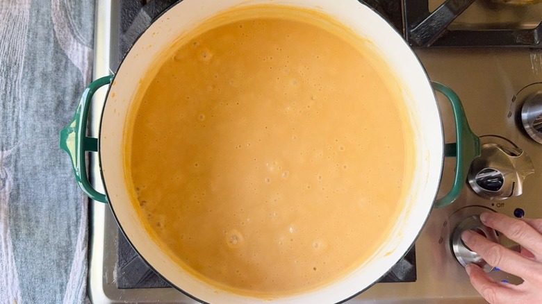 beer cheese pretzel dip cooking in large pot on stovetop