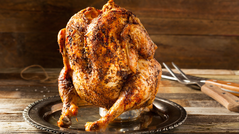 Beer can chicken with BBQ tongs