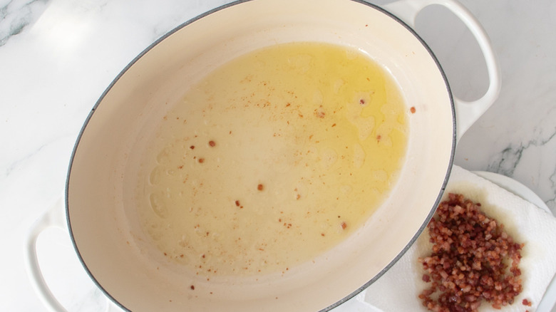 Large Dutch oven with oil next to plate with pancetta