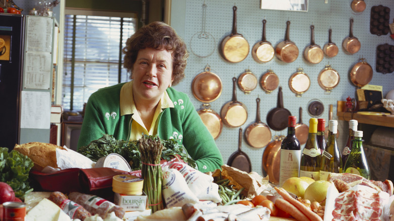 The late celebrity chef Julia Child sits at a food and wine covered table