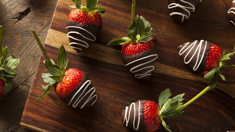 Chocolate-covered strawberries on a wooden board