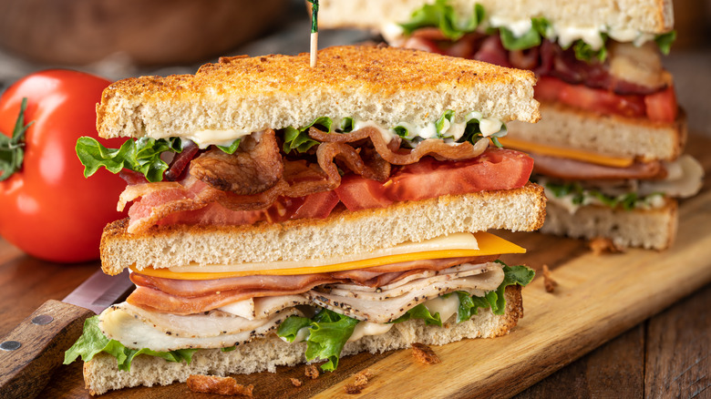 A club sandwich and fries on a cutting board