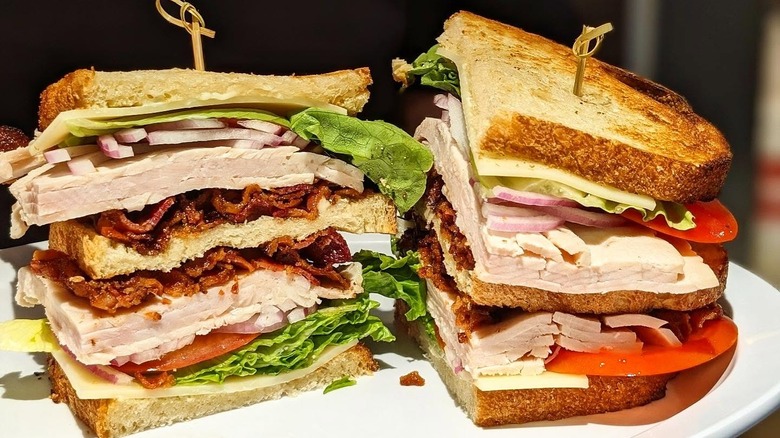 A turkey club sandwich on a plate at Zaidy's Deli & Bakery